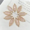 Détail de breloques ovales en cristal rose facetté avec doubles boucles dorées - Quartz rose