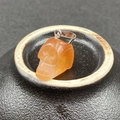 Dettaglio di un ciondolo a teschio in agata arancione con chiusura in metallo argento - Agata rossa