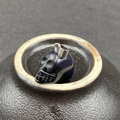 Vue détaillée d'un pendentif crâne en grès bleu avec fermoir métallique sur céramique - Grès Bleu (Synthétique)