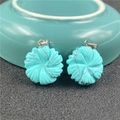 Detailed close-up of turquoise flower pendants with natural black mineral veins and silver clasps - Synthetic Blue Turquoise
