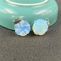 Dettaglio macro di due ciondoli a fiore in opale blu intagliato con ganci in argento - Opalite