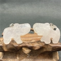 Vue détaillée de deux pendentifs éléphants en cristal translucide sur socle en bois - Quartz rose