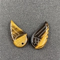 Macro detail of tiger eye stone angel wing pendants with natural golden texture - Tiger's Eye
