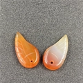 Macro detail of orange carnelian angel wing pendants with carved texture for DIY jewelry - Red Agate