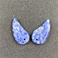 Macro view of blue sodalite angel wing charms with natural white marbling and drill holes - Blue Spot Jasper