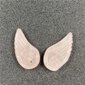 Macro detail of hand-carved pink rose quartz angel wing pendants with drilled holes - Rose Quartz