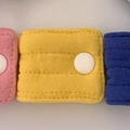 Pink yellow and blue fabric cable organizer with snap buttons in a row for cord storage - Quilted Yellow