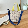 Borsa a secchiello trapuntata con stampa cucciolo, manici gialli e tracolla blu - Stile a tracolla