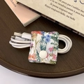 Floral fabric cable organizer with white snap button for headphone cord storage - Quilted Wildflower