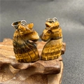 Macro shot of tiger eye stone chess knight pendants with polished silver metal bails - Tiger Eye Horse Head Style