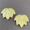 Detailed view of two maple leaf shaped green stone pendants with natural vein patterns - Unakite 1PC