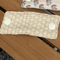 Beige woven fabric cable organizer with white resin buttons on a dark wood background - Off-White Diamond Pattern