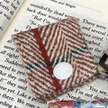 Brown herringbone fabric cable organizer with white button on vintage book pages - Woolen Herringbone