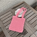 Sac à main en corde de coton rose tissé à la main présenté sur une table en bois - Rose