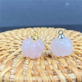 Vue macro de pendentifs citrouille en quartz rose avec boucles en or et argent sur tapis - Quartz rose