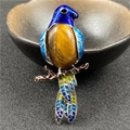 Bird brooch with blue enamel wings and tiger eye stone set on a golden branch - Tiger's Eye