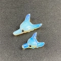 Macro detail of hand-carved opal glass dolphin pendants with smooth texture and blue glow - Synthetic Opal (Large) / Opal White
