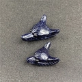 Detailed view of wolf head pendants carved from blue goldstone with metallic sparkles - Blue Sandstone (Large) / Blue