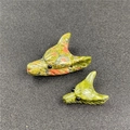 Macro detail of hand-carved stone wolf head pendants in various natural mineral textures - Unakite (Large) / Green