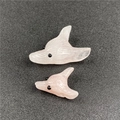 Close-up of hand-carved rose quartz fox head pendants in small and large sizes - Pink