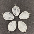 Close-up of five teardrop crystal pendants with silver loops on black surface - White Crystal