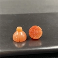 Dettaglio macro di perle in agata arancione intagliate a forma di melograno e loto - Agata rossa