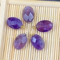 Detailed view of oval faceted purple agate pendants with gold and silver bail connectors - Amethyst