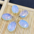 Macro detail of blue oval opal pendants with radial texture and metal bail hooks - Opalite