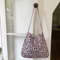 Pink leopard print tote bag with purple stars hanging on a white door handle - Purple Leopard