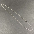 Detail of silver O-shaped copper chain with lobster clasp on dark textured surface - Silver