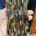 Close-up of polished 3x12mm cylindrical agate beads showing natural banded textures - Yellow Plaid
