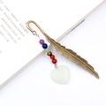 Vintage bronze feather bookmark with chakra stones and a translucent white heart pendant - Luminous Stone