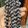 Close-up of 3x12mm cylindrical agate beads with natural black and white striped patterns - Black & White