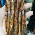 Macro detail of 3x12mm natural agate cylinder beads in orange and brown gradient hues - Black and Yellow