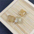 Macro shot of three yellow rose quartz clover pendants with faceted edges on bamboo - Yellow Topaz Pendant