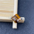 Macro view of a tiger eye four-leaf flower connector with silver metal rings for DIY jewelry - Tiger's Eye Connector