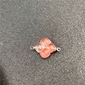 Macro detail of a carved pink quartz clover connector with metallic hanging loops - Pink Connector