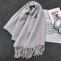 Écharpe en maille gris clair à longues franges avec accessoires lifestyle sur fond texturé - 67*180cm / Gris clair