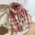 Pink and beige checkered scarf with tassels draped elegantly on a modern white chair - Watermelon red