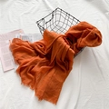 Écharpe légère en coton et lin orange vif avec bords effilochés dans un panier - Orange vif