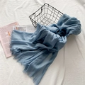 Écharpe bleu clair en coton et lin avec bords effilochés dans un décor épuré - Bleu ciel