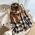 Écharpe à carreaux et franges tons café et camel posée sur une chaise douillette - Marron