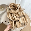 Thick plaid scarf with warm beige and brown tassels in a cozy home setting - Khaki