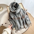 Checkered winter scarf in grey and brown tones with fringe detail on an armchair - Grey Blue Plaid