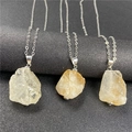 Detalle de colgantes de piedra natural geométrica con una fina cadena en tono plateado - Citrino