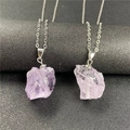 Macro shot of two irregular purple amethyst gemstone pendants on fine silver chains - Light Amethyst