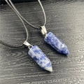 Detailed macro view of two blue marble hexagonal column pendants with metal clasps - Blue Spot Jasper