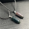 Detailed macro view of two hexagonal crystal pendants in dark green and deep reddish brown stone - India Agate