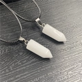 Detailed macro view of two white hexagonal crystal pendants with silver metal clasps - White Jade