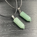 Detalle de dos colgantes de cristal verde hexagonal en collares negros trenzados - Aventurina Verde